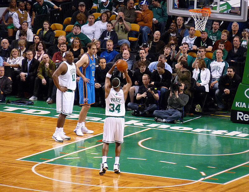 NBA player taking a free throw with defenders ready to rebound during a game.